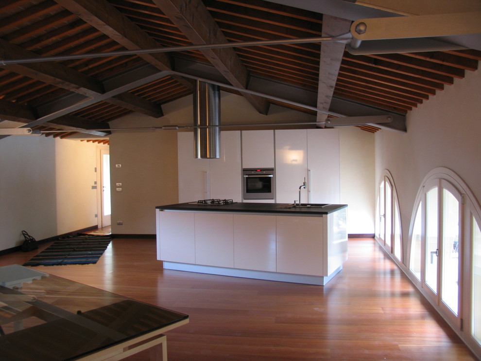 Modelo de salón abierto de estilo de casa de campo grande con paredes blancas y suelo de madera oscura