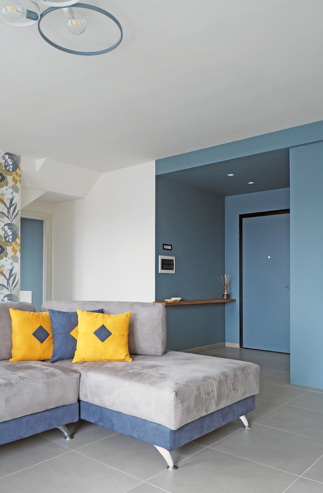 Foto di un soggiorno moderno di medie dimensioni e aperto con libreria, pareti bianche, pavimento con piastrelle in ceramica, TV a parete e pavimento grigio