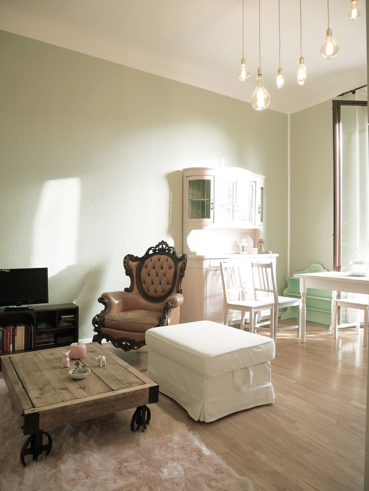 На фото: маленькая открытая гостиная комната в стиле фьюжн с зелеными стенами и темным паркетным полом для на участке и в саду