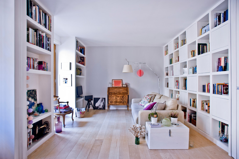 This is an example of a medium sized scandinavian open plan games room in Rome with a reading nook, grey walls, light hardwood flooring, a freestanding tv and beige floors.