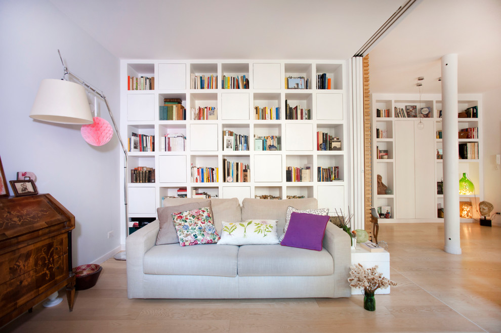 Modelo de sala de estar con biblioteca abierta nórdica de tamaño medio con paredes blancas, suelo de madera clara y suelo marrón