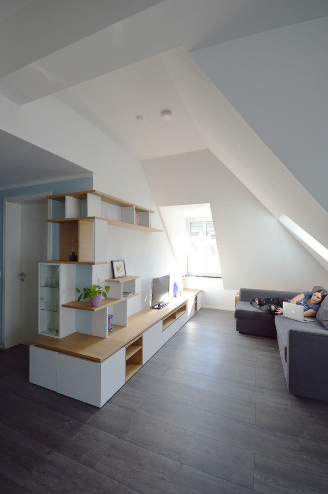 Exempel på ett stort modernt allrum med öppen planlösning, med en hemmabar, vita väggar, mörkt trägolv, en fristående TV och grått golv