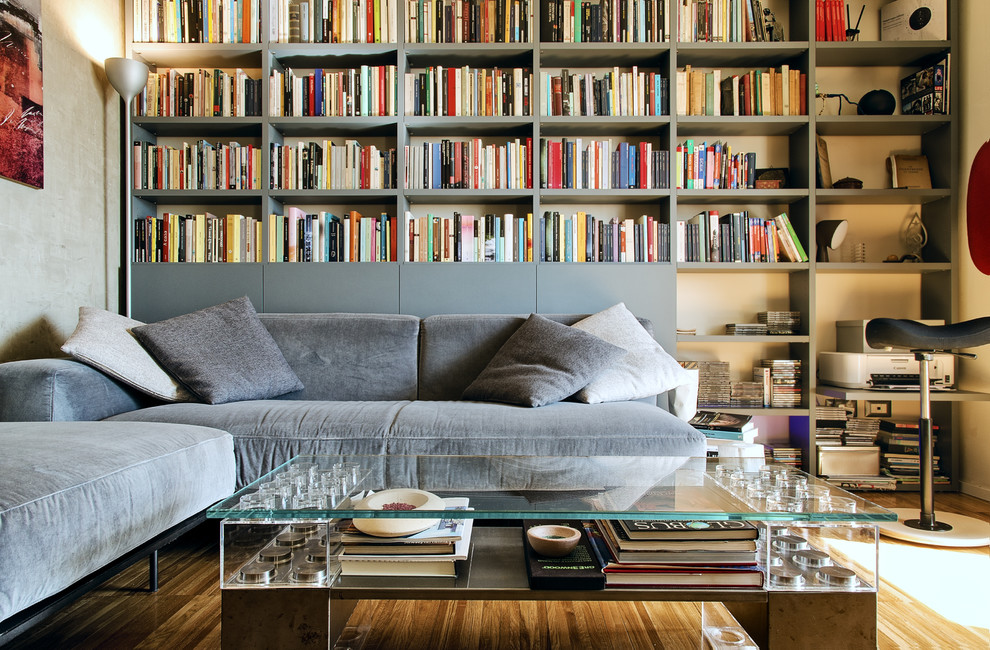 Foto de sala de estar con biblioteca cerrada contemporánea de tamaño medio sin chimenea y televisor con paredes grises y suelo de madera oscura