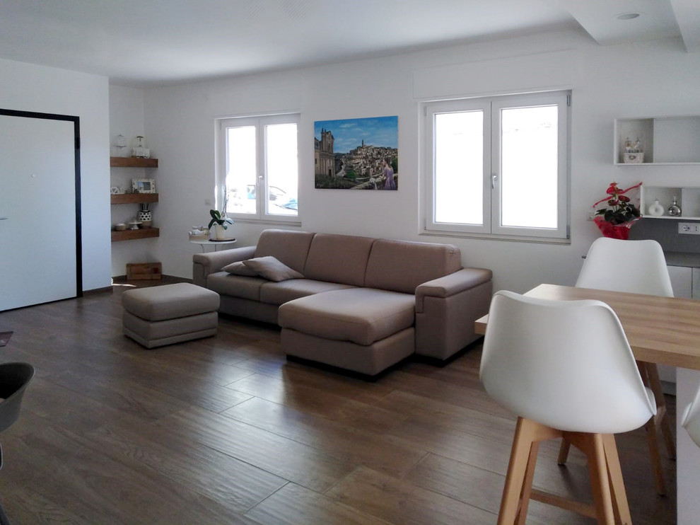 Mittelgroßes, Offenes Modernes Wohnzimmer ohne Kamin mit weißer Wandfarbe, Porzellan-Bodenfliesen, TV-Wand und braunem Boden in Sonstige