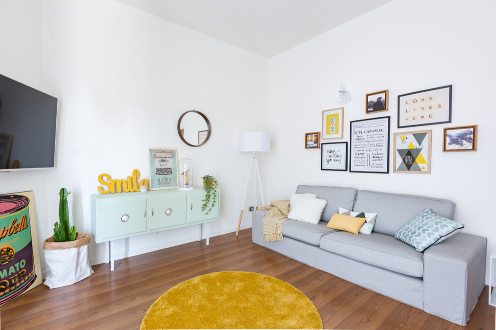 Mittelgroßes, Offenes Nordisches Wohnzimmer mit weißer Wandfarbe, braunem Holzboden, TV-Wand und braunem Boden in Rom