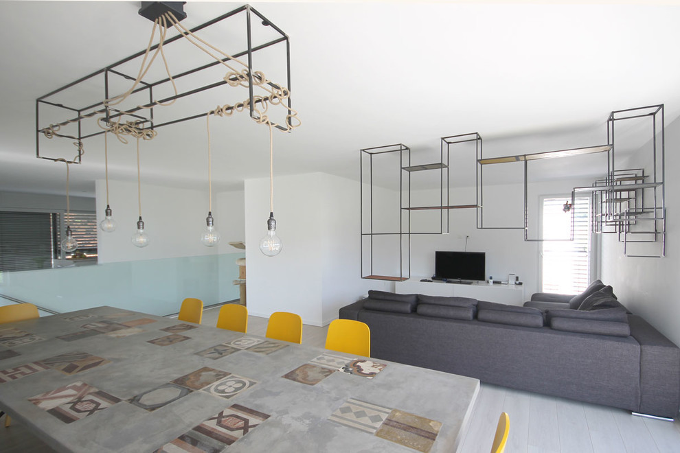 Idee per un soggiorno minimal di medie dimensioni e aperto con libreria, pareti bianche, pavimento in legno verniciato e TV autoportante