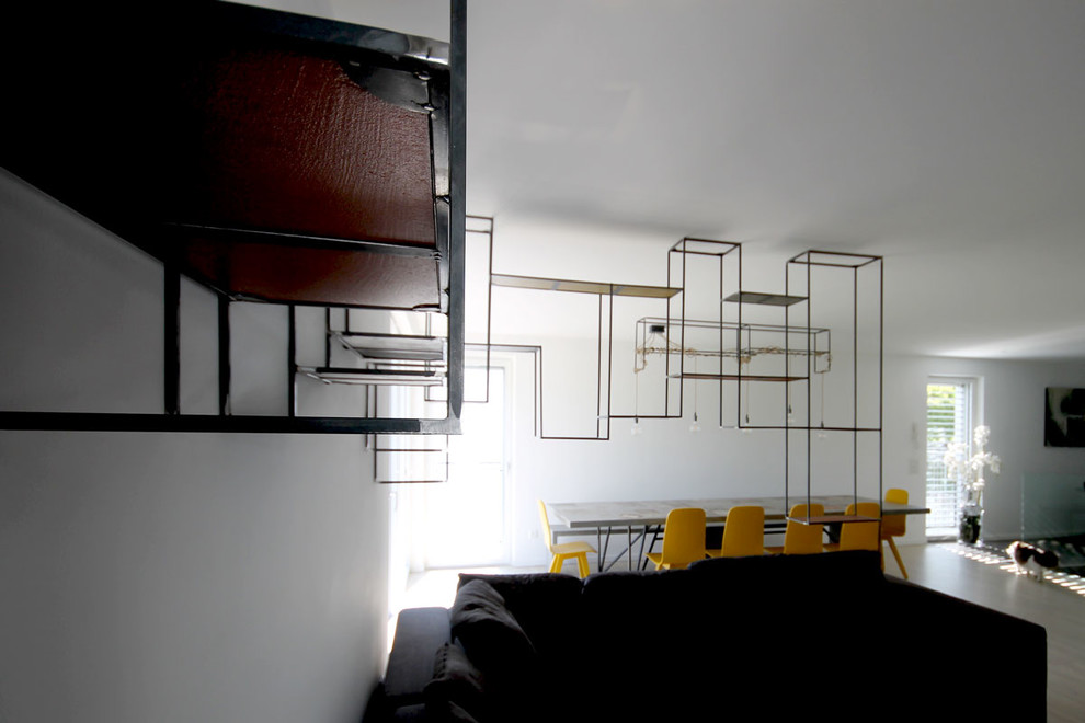 Ispirazione per un soggiorno design di medie dimensioni e aperto con libreria, pareti bianche e pavimento in legno verniciato