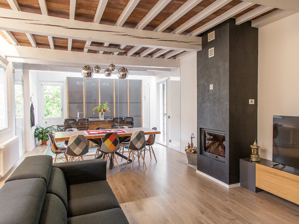 Mittelgroßes, Offenes Modernes Wohnzimmer mit weißer Wandfarbe, braunem Holzboden, Kamin, braunem Boden und freistehendem TV in Sonstige