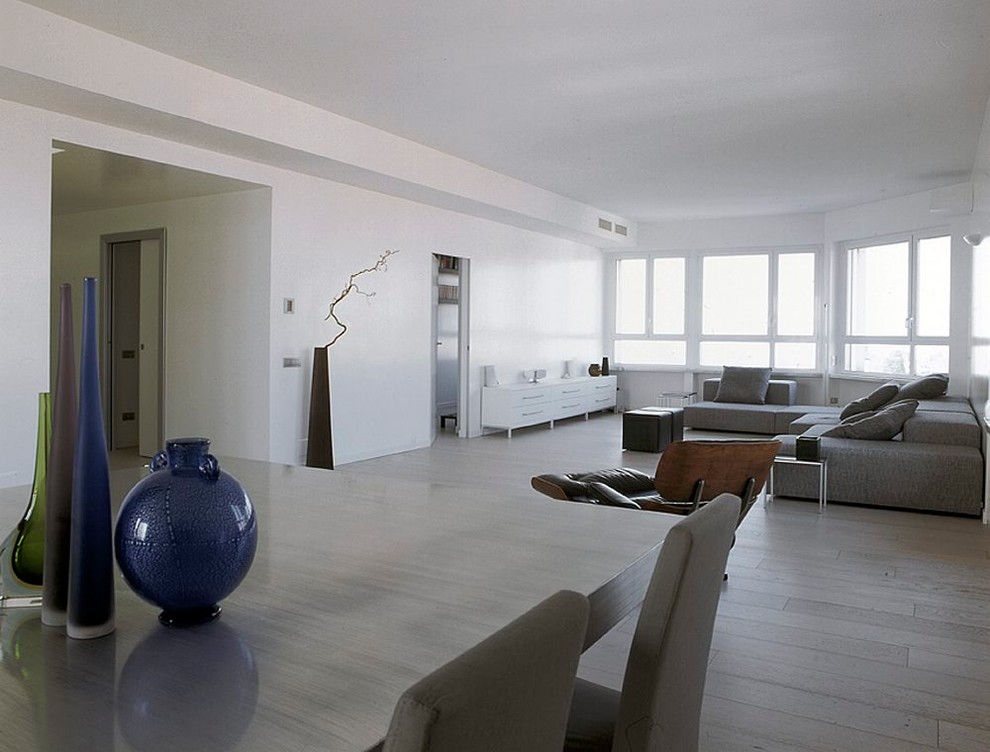 Foto di un ampio soggiorno moderno stile loft con pareti bianche, parquet chiaro, TV nascosta e pavimento bianco
