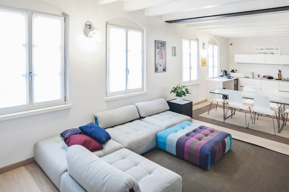 Immagine di un soggiorno minimal di medie dimensioni e aperto con pareti bianche, parquet chiaro e parete attrezzata