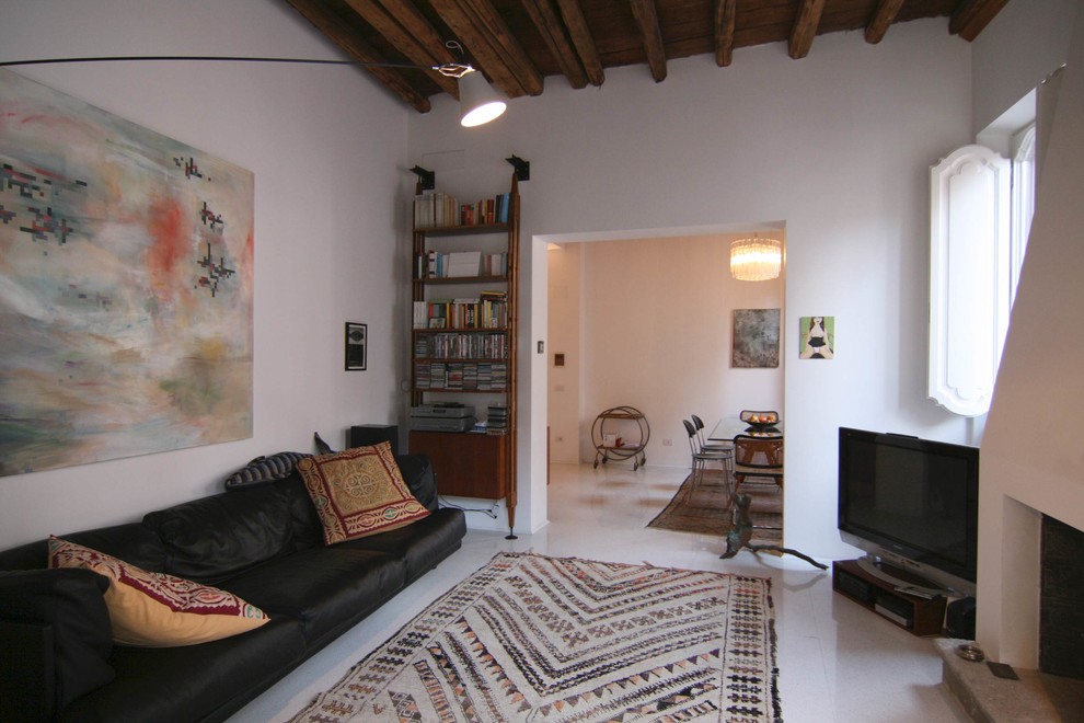 Ejemplo de sala de estar mediterránea con paredes blancas, todas las chimeneas, marco de chimenea de yeso y televisor independiente