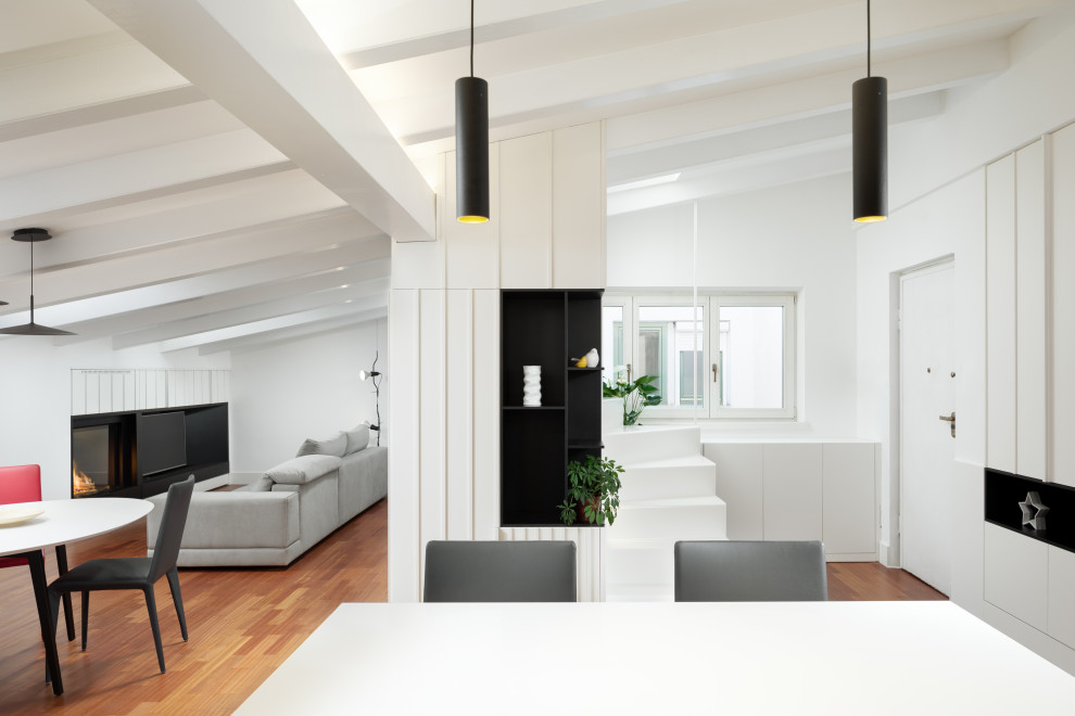 Foto de sala de estar tipo loft minimalista grande con paredes blancas, suelo de madera en tonos medios, todas las chimeneas, marco de chimenea de metal y pared multimedia