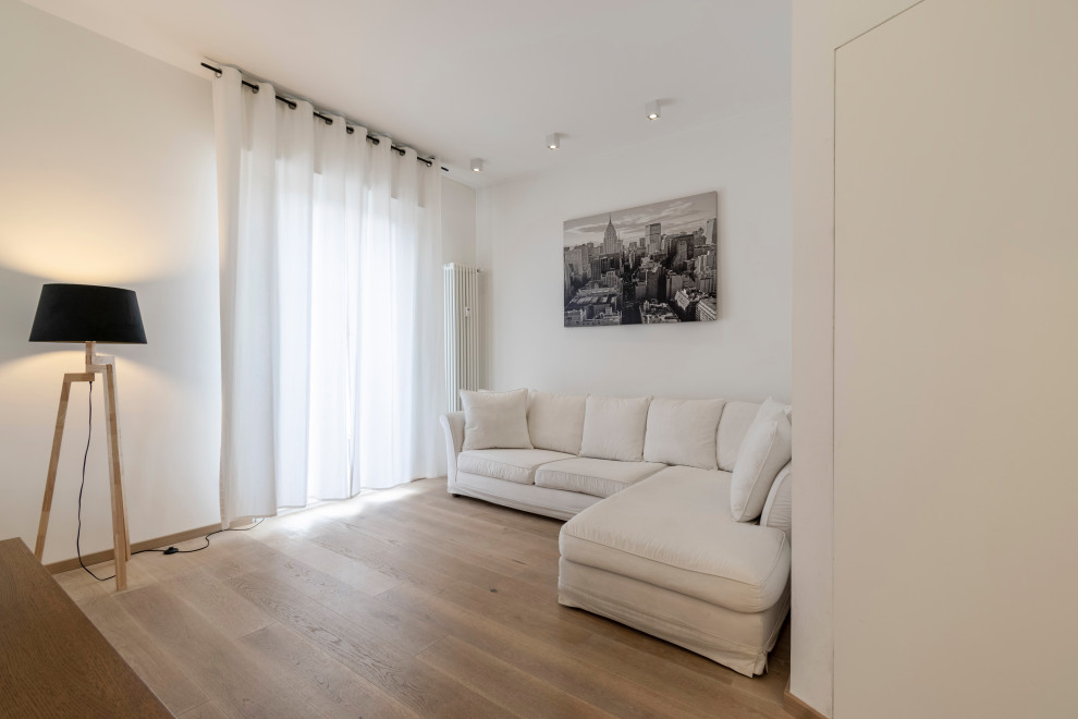 Idee per un soggiorno minimal di medie dimensioni con pareti bianche, parquet chiaro e pavimento beige