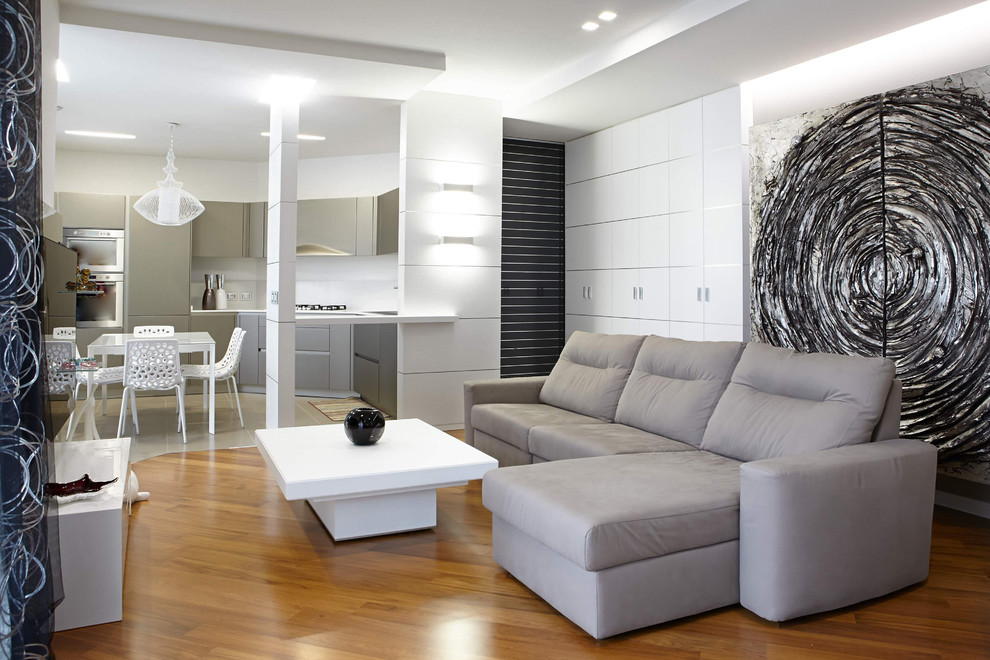 Foto de salón abierto contemporáneo de tamaño medio con paredes blancas y suelo de madera clara