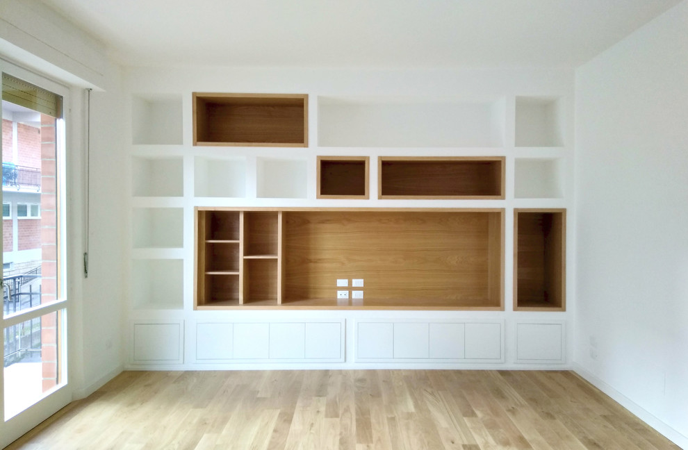 Immagine di un soggiorno design di medie dimensioni e aperto con libreria, pareti bianche e parquet chiaro