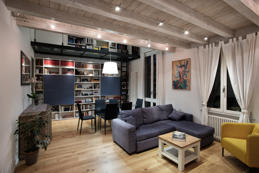 Idee per un soggiorno design aperto e di medie dimensioni con pareti bianche, parquet chiaro e libreria