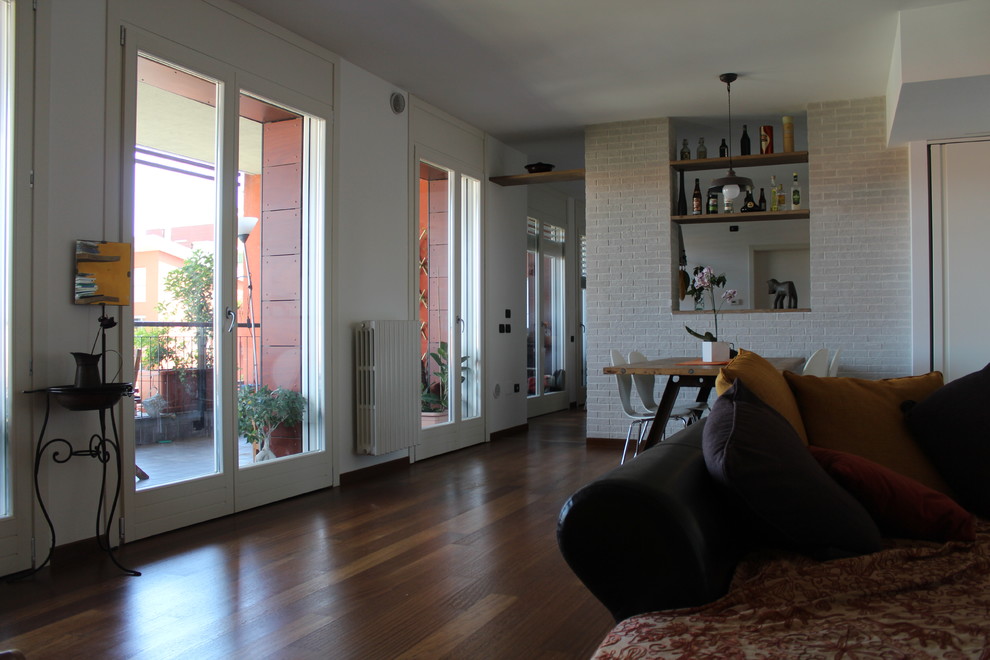 Großes, Offenes Industrial Wohnzimmer mit weißer Wandfarbe und braunem Holzboden in Mailand