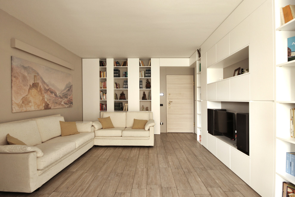 Idée de décoration pour un petit salon minimaliste ouvert avec une bibliothèque ou un coin lecture, un mur beige, un sol en carrelage de porcelaine, un téléviseur encastré et un sol gris.