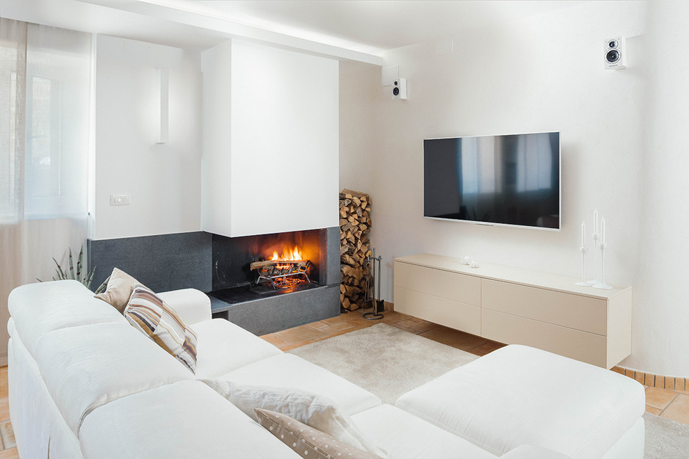 Offenes Modernes Wohnzimmer mit weißer Wandfarbe, Terrakottaboden, Gaskamin, Kaminumrandung aus Beton und TV-Wand in Neapel