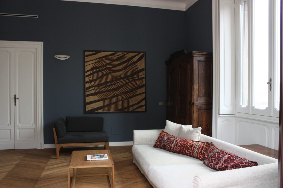 Foto di un soggiorno minimalista di medie dimensioni e chiuso con sala della musica, pareti blu, parquet chiaro e TV a parete