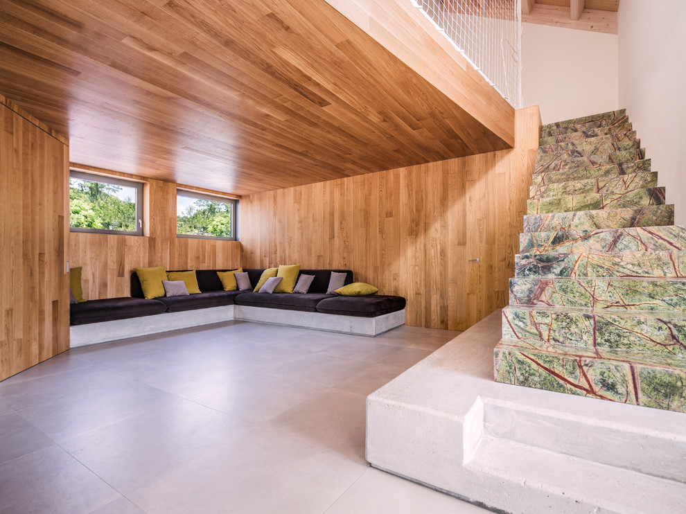Esempio di un grande soggiorno stile rurale aperto con pavimento in gres porcellanato, TV nascosta, pareti marroni e pavimento grigio