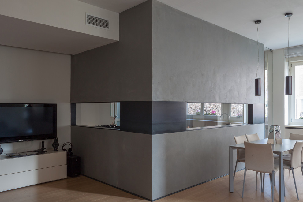 Idée de décoration pour un grand salon design ouvert avec un mur gris, parquet clair, aucune cheminée et un téléviseur fixé au mur.