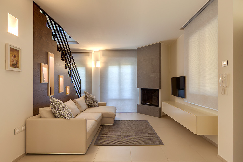 Diseño de sala de estar abierta actual con paredes beige, marco de chimenea de metal, televisor colgado en la pared, chimenea de esquina y alfombra