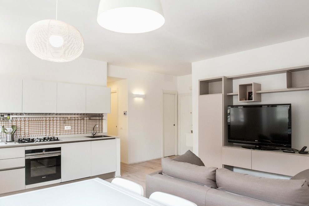 Пример оригинального дизайна: открытая гостиная комната среднего размера в современном стиле с белыми стенами, паркетным полом среднего тона, отдельно стоящим телевизором и коричневым полом
