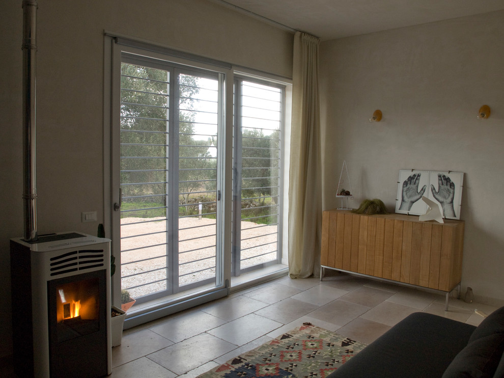 Diseño de salón abierto moderno de tamaño medio con suelo de piedra caliza, estufa de leña, paredes grises y suelo beige