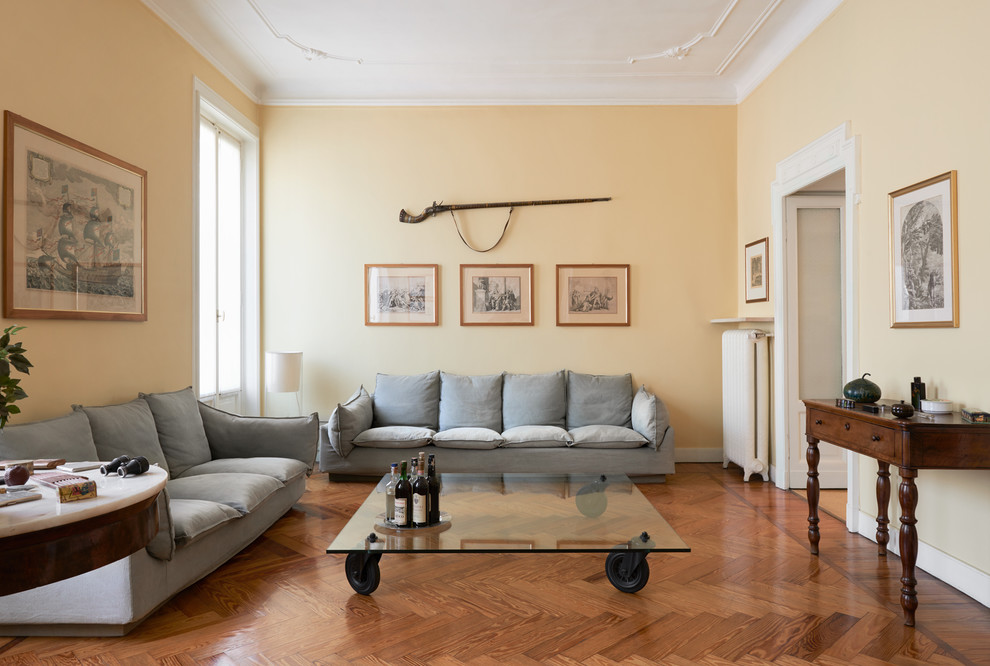 Großes, Repräsentatives, Abgetrenntes Modernes Wohnzimmer mit gelber Wandfarbe und braunem Holzboden in Mailand