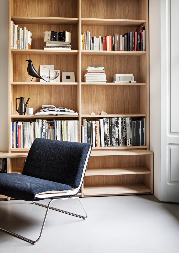 Foto di un soggiorno minimalista di medie dimensioni e stile loft con libreria, pareti bianche e TV a parete