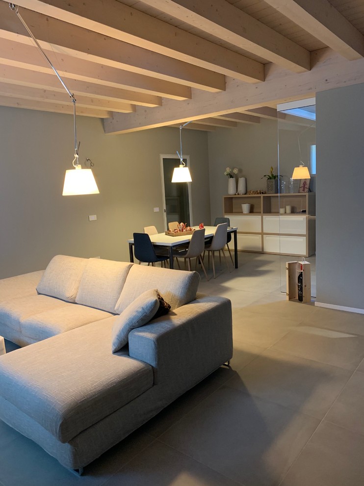 На фото: открытая гостиная комната среднего размера в современном стиле с серыми стенами, полом из керамогранита и серым полом