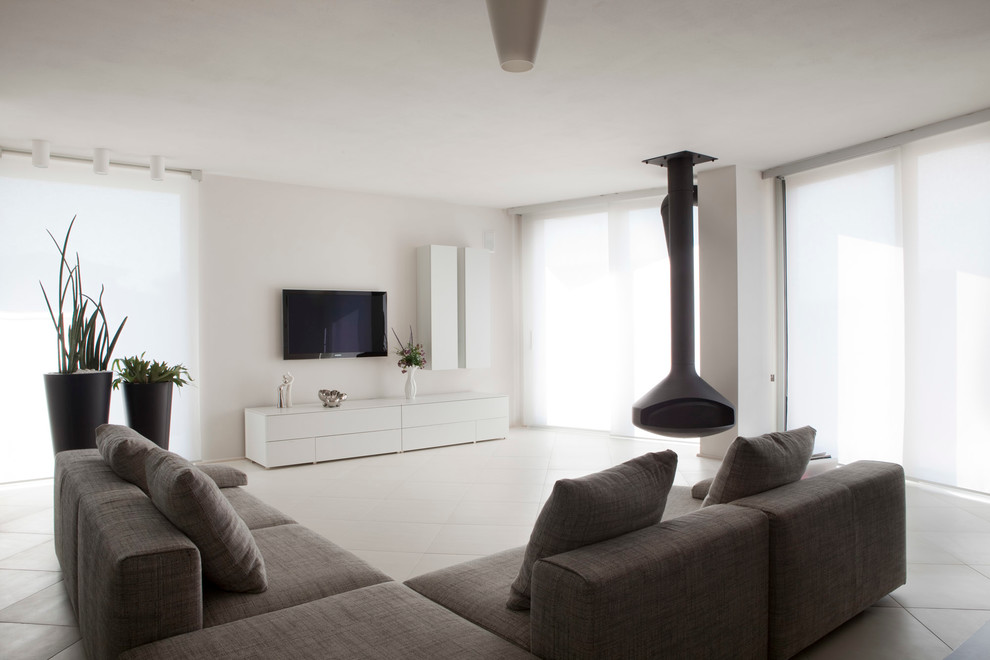 На фото: большая парадная гостиная комната в современном стиле с белыми стенами, подвесным камином и телевизором на стене