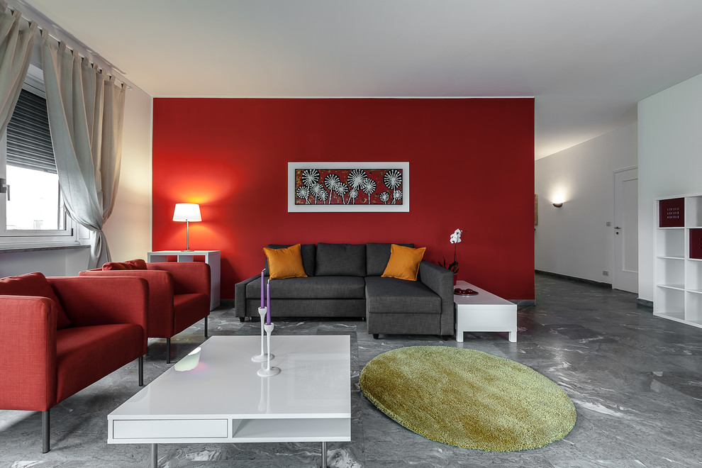 Design ideas for a contemporary open plan living room in Milan with red walls, marble flooring and feature lighting.