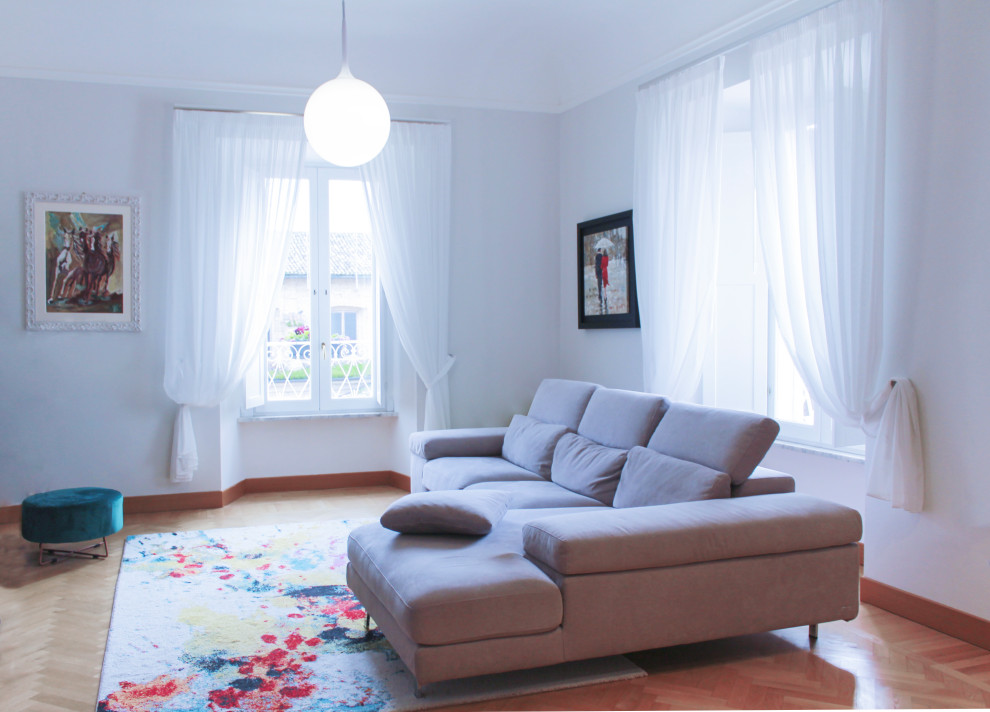 Пример оригинального дизайна: огромная открытая гостиная комната в стиле модернизм с серыми стенами, светлым паркетным полом, телевизором на стене и коричневым полом