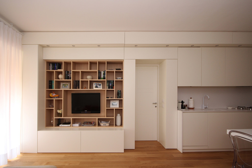 Imagen de biblioteca en casa abierta contemporánea pequeña con paredes blancas, suelo de madera en tonos medios, televisor colgado en la pared y suelo amarillo