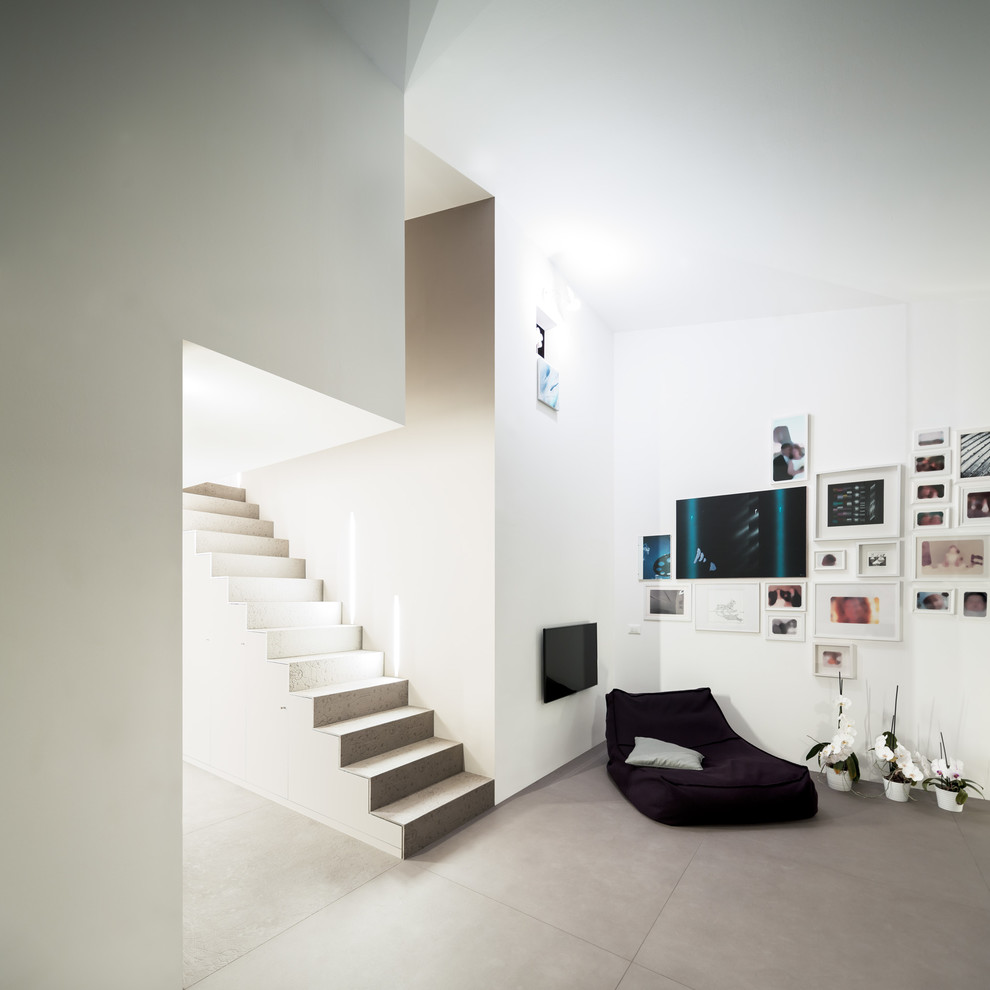 Idee per un soggiorno contemporaneo aperto con pareti bianche, pavimento in gres porcellanato e TV a parete