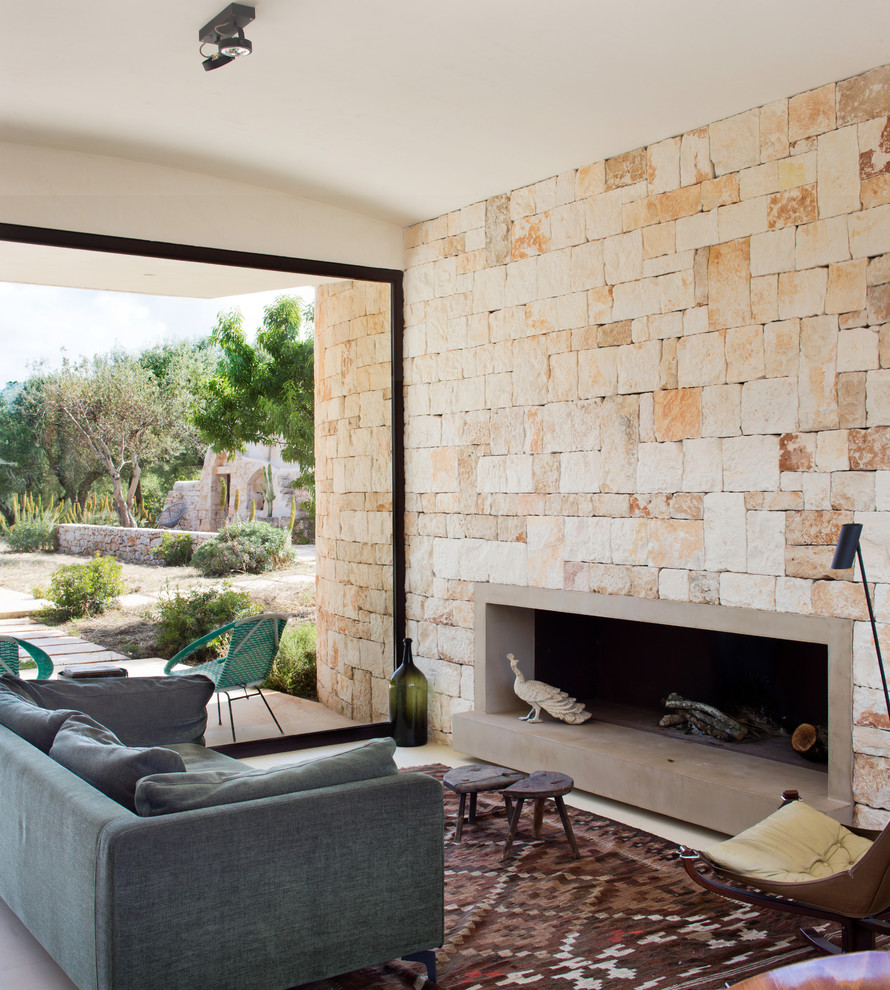 Стильный дизайн: парадная гостиная комната в средиземноморском стиле с горизонтальным камином, фасадом камина из бетона и ковром на полу без телевизора - последний тренд