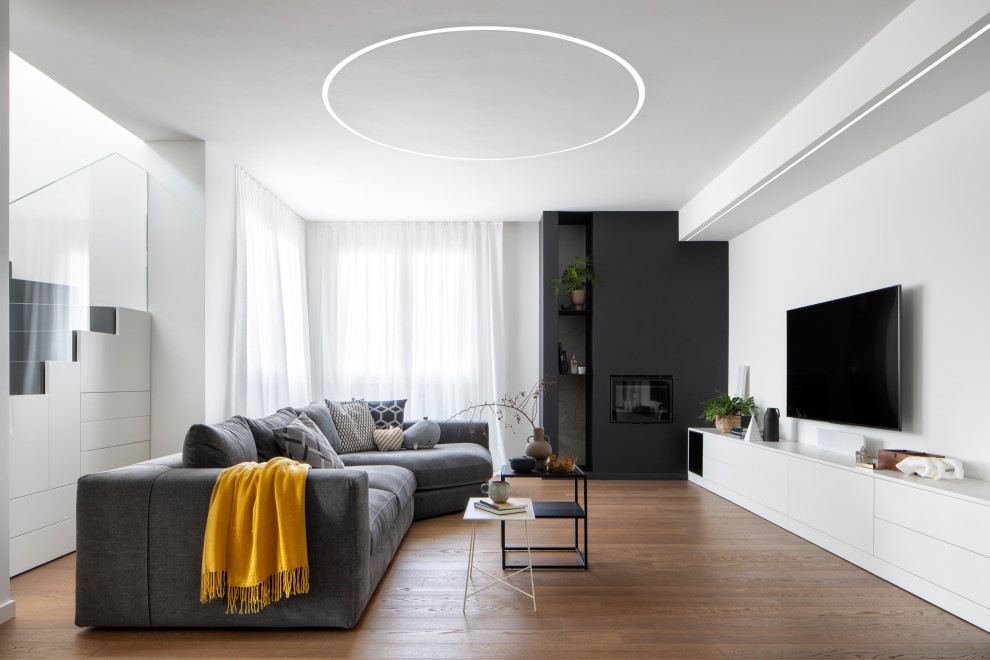 Large contemporary open plan living room in Milan with white walls, dark hardwood flooring, a standard fireplace, a plastered fireplace surround, a wall mounted tv and brown floors.