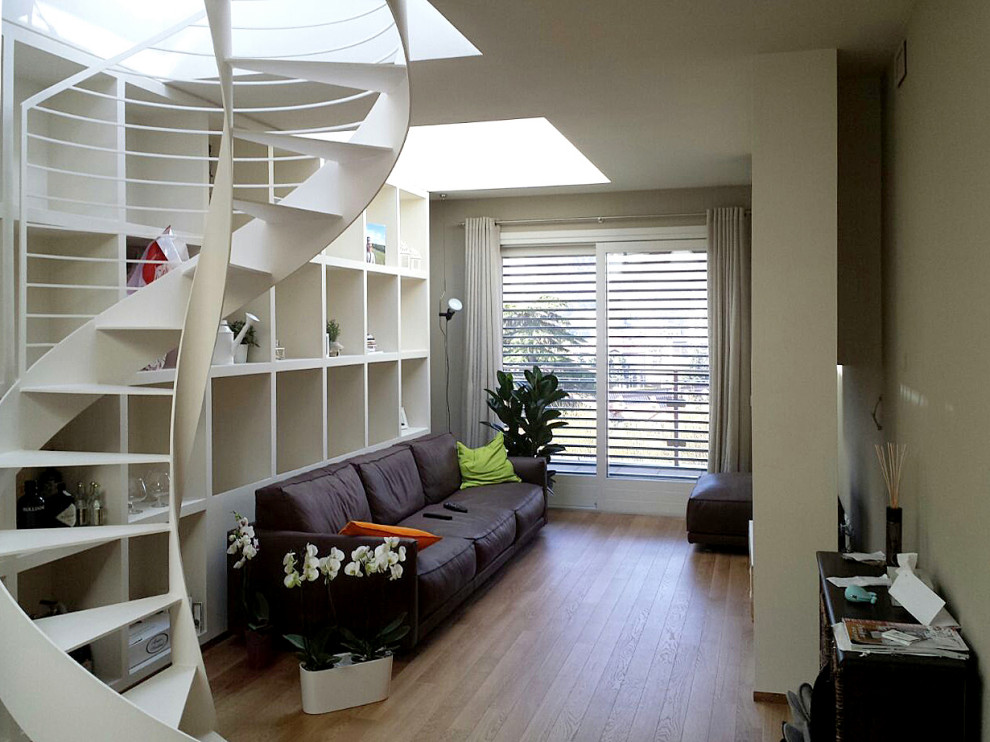 Ispirazione per un soggiorno design di medie dimensioni e aperto con libreria, pareti bianche, parquet chiaro, TV a parete e pavimento marrone