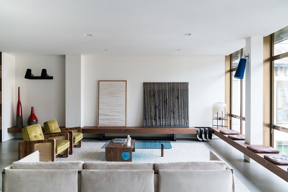 Esempio di un soggiorno design chiuso con sala formale, pareti bianche, pavimento in cemento e pavimento grigio