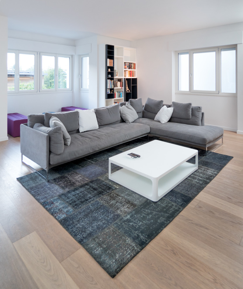 Foto de sala de estar abierta actual extra grande con suelo de madera en tonos medios, televisor colgado en la pared y paredes blancas