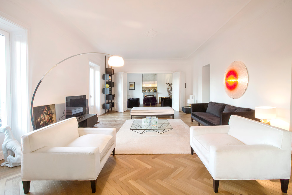 Repräsentatives Modernes Wohnzimmer mit weißer Wandfarbe, hellem Holzboden und freistehendem TV in Mailand