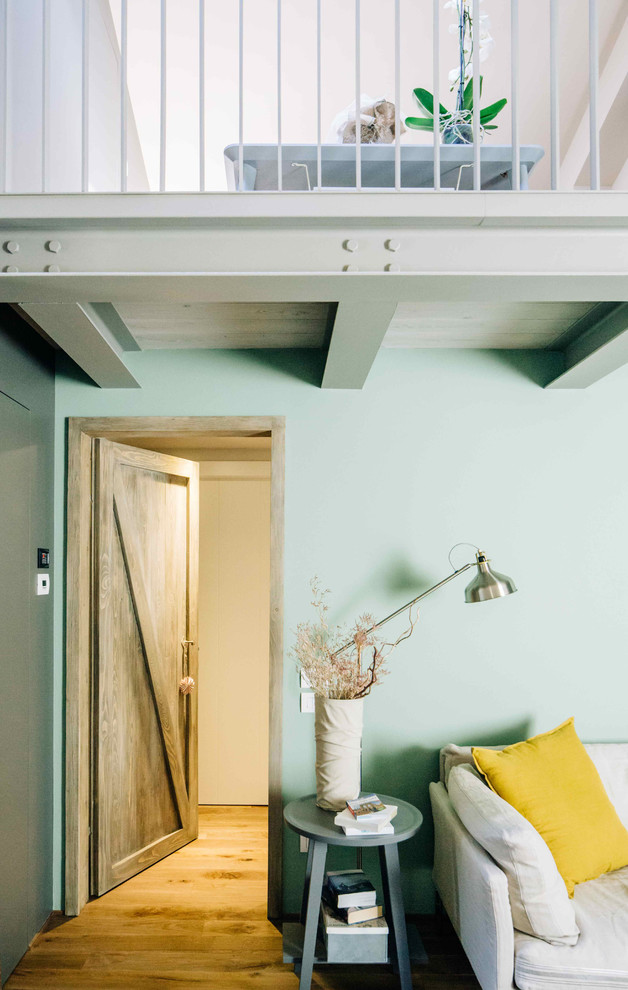 Esempio di un soggiorno minimal con pareti multicolore, pavimento in legno massello medio e TV a parete