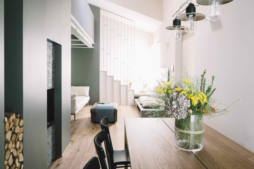 Foto di un soggiorno minimal stile loft con pareti multicolore, pavimento in legno massello medio e TV a parete