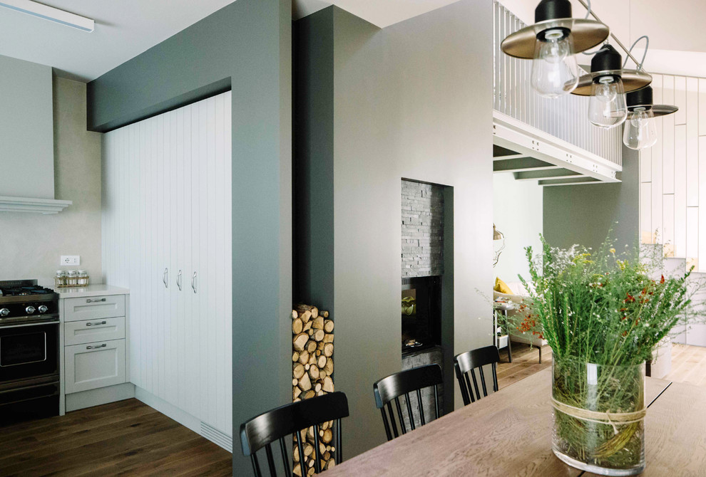 Immagine di un soggiorno design stile loft con pareti multicolore, pavimento in legno massello medio e TV a parete