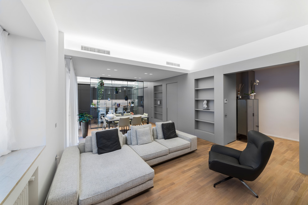 Immagine di un soggiorno minimalista di medie dimensioni e aperto con pareti grigie e pavimento in legno massello medio