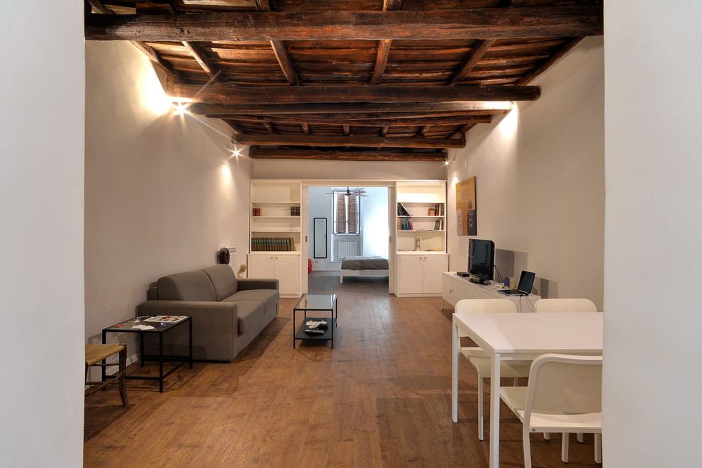 Esempio di un piccolo soggiorno moderno stile loft con pareti bianche e pavimento in legno massello medio