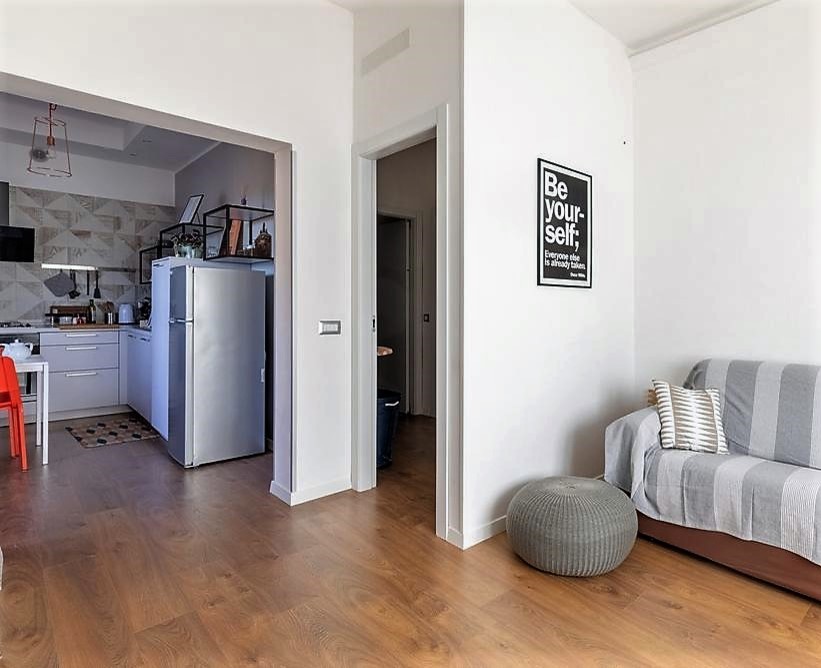 Immagine di un piccolo soggiorno design aperto con pareti bianche, parquet scuro e pavimento marrone