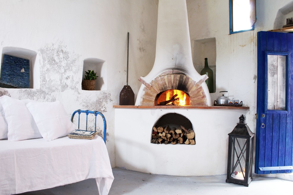 Mediterranes Wohnzimmer mit weißer Wandfarbe und Betonboden in Bologna